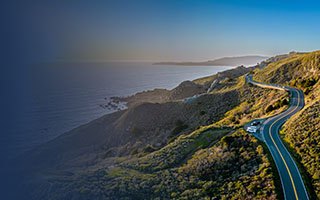 Highway 1 winding through a hilly, coastal countryside