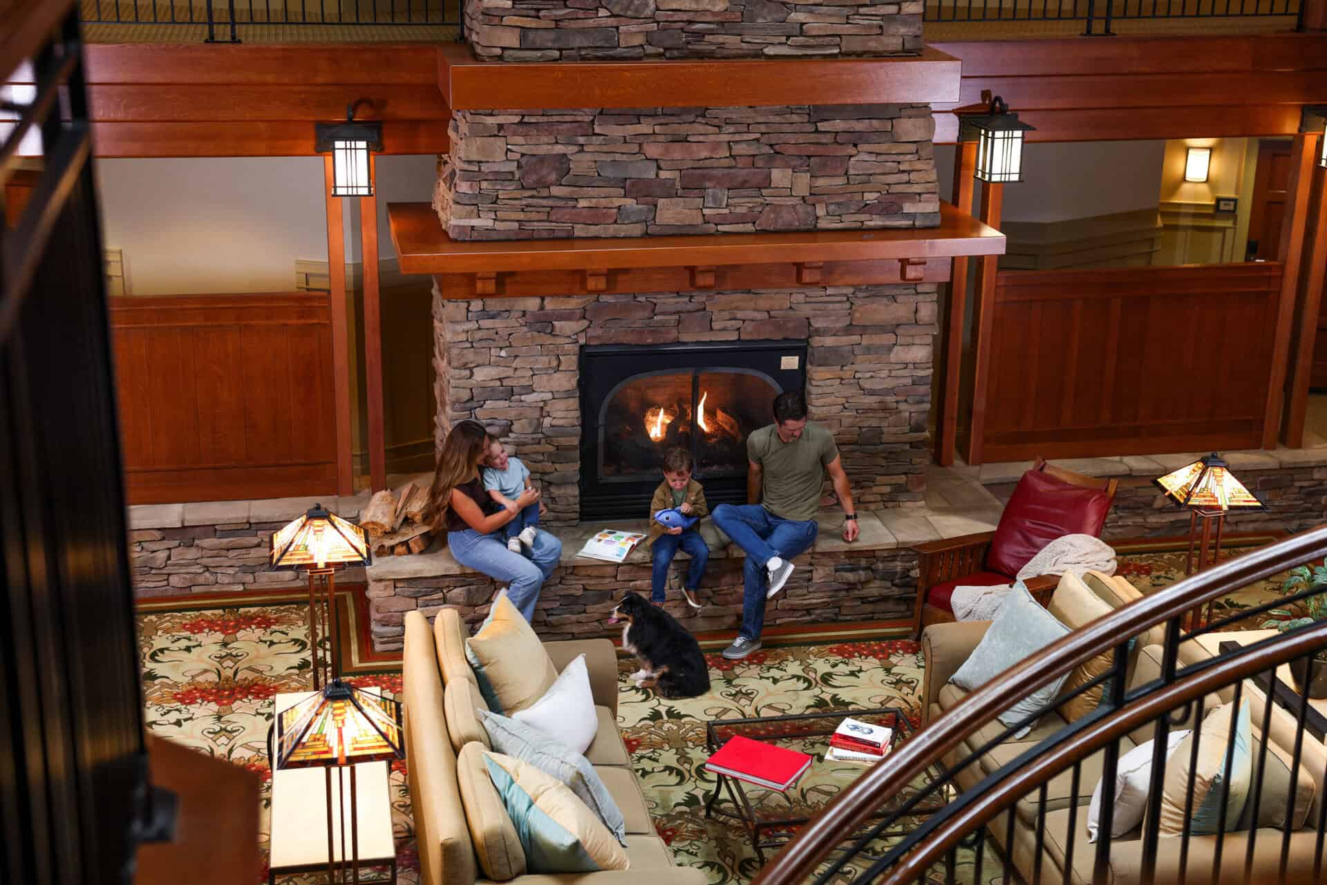 family at the fireplace at Avila Village Inn